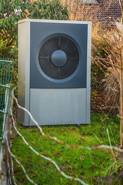 Air source heat pump installed outside in a garden, green renewable energy concept of heat pump