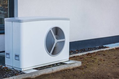 Air source heat pump installed outside a house, green renewable energy concept of heat pump