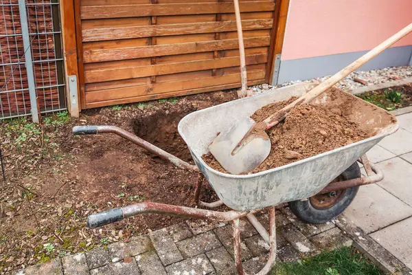 土とシャベルを備えたホイールバロー 木や構造を植えるための穴を掘る — ストック写真