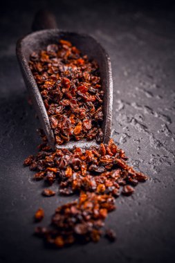 Kurumuş organik berberiler ve siyah kara zeminde kepçe.