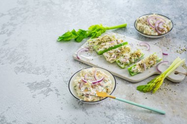 Yumurta ve ton balığı salatasıyla dolu kereviz çubukları, sağlıklı sebzeler ve antipasti atıştırmalıkları.