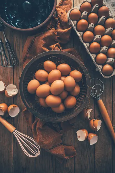 Frische Bio Eier Mit Küchen Und Backutensilien Auf Holztisch lizenzfreie Stockbilder