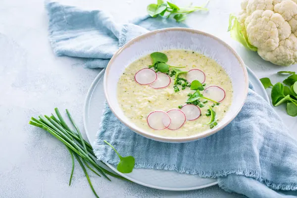 クリーミーな白いカリフラワースープ 大根とチャイフ ハーブ付きの健康的な食べ物 ロイヤリティフリーのストック画像