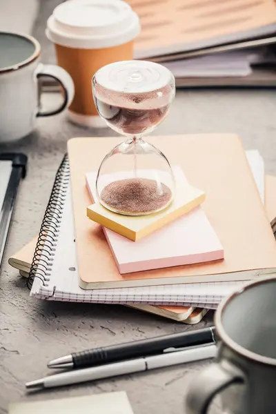 stock image Crop of hourglass on home office table count measure time.  Workplace of busy employee, time management and burnout concept