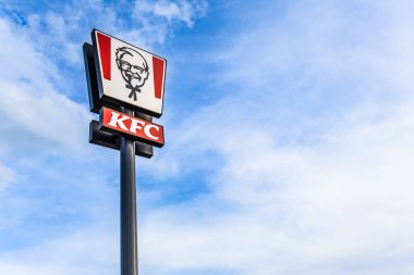 KFC Kentucky Fried Chicken fast food restoranının logosu. Mavi gökyüzüne karşı Amerikan fast food tabelası