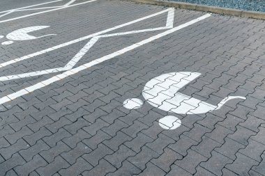 Boş otoparkta çocuklu aileler için ayrılmış bir ebeveyn ve çocuk park yeri tabelası.