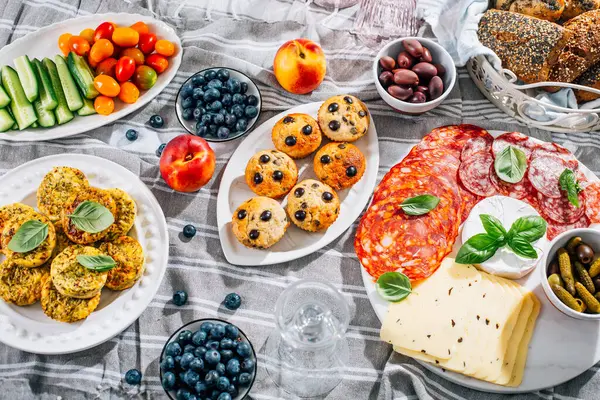 Piknik, mezeler, peynir ve et tabağı, tatlı ve lezzetli kekler ve meyveler.