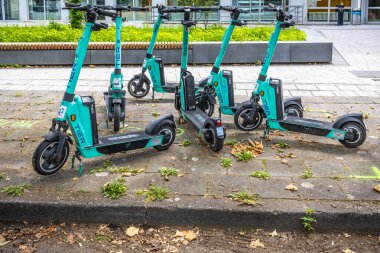 Ludwigshafen, Almanya - 29 Haziran 2024: Tier kiralık elektrikli scooter 'lar şehir modern binasının önüne park edildi, kasaba kiralık parkı