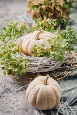 Şükran Günü ve Cadılar Bayramı için mutfak masasında çelenk ve beyaz balkabağı olan masa dekorasyonu.