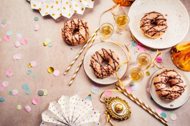 İçkili lezzetli çörekler, konfeti, flamalar ve yeni yıl için parti şapkaları, doğum günü
