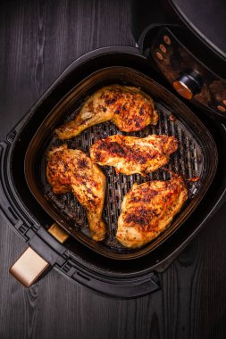 Tavuk budu ve parçaları uçak kızartıcısında, modern yemek - sulu barbekü eti hazırlamak