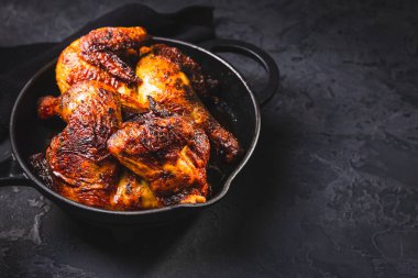 Siyah arka planda demir tavuklu leziz ızgara tavuk.