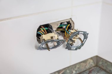 Kırık prizler ve soketler araçlar ve ammetreyle onarılıyor ve onarılıyor