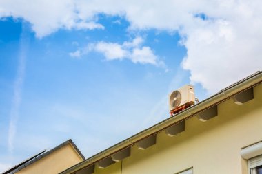 Çift dönüştürücü kompresör, klima kompresörü ve ısıtma pompasının kombinasyonu, aile evinin çatısına kurulmuş.