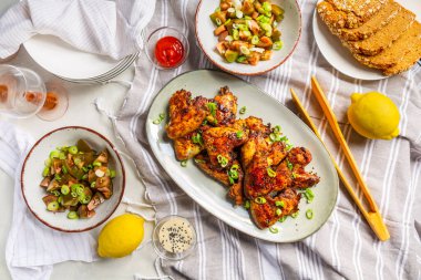 Piknik masası ve açık havada yemek, karışık salatalı tavuk kanadı.