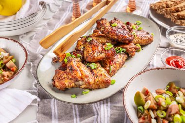 Piknik masası ve açık havada yemek, karışık salatalı tavuk kanadı.