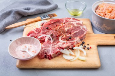 Çiğ domuz eti. Tuz, soğan ve lahana turşusuyla kesilmiş taze biftekler.