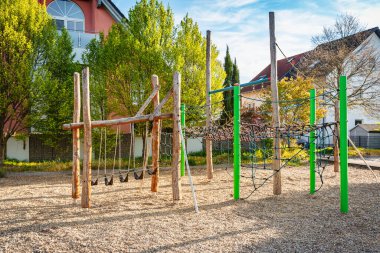 Güneşli bir günde boş oyun parkı Tahtadan yapılmış oyun teçhizatlarıyla