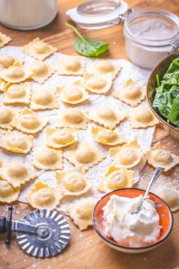 Çiğ ravioli, İtalyan makarnası, ıspanak ve peynirle dolu, pişirmeye hazır.