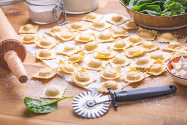 Çiğ ravioli, İtalyan makarnası, ıspanak ve peynirle dolu, pişirmeye hazır.