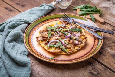 Mantar, soğan ve roka soslu vejetaryen fritatta.