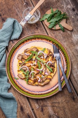 Mantar, soğan ve roka soslu vejetaryen fritatta.