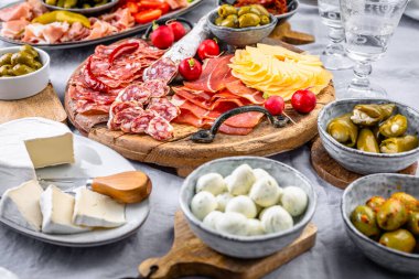 Ahşap tepside çeşitli aperatifler ve antipasti tabakları et ve peynirle servis konsepti.