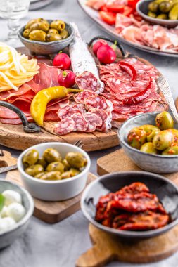 Ahşap tepside çeşitli aperatifler ve antipasti tabakları et ve peynirle servis konsepti.
