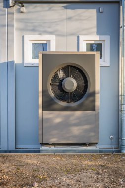 Air source heat pump installed outside a house, green renewable energy concept of heat pump