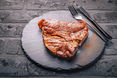 Biftek ve siyah servis tabağında baharat.