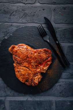 Biftek ve siyah servis tabağında baharat.