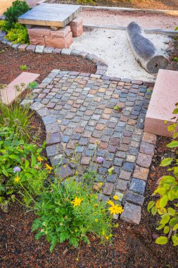 Peyzaj şekilli bahçe tasarımı fikirleri: doğal elementlerin olduğu yol ve oturma alanı