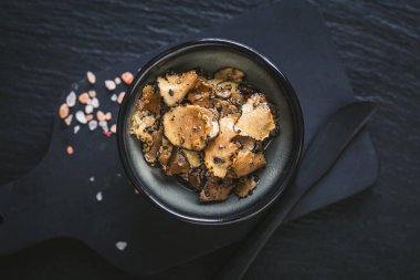 Yermantarı, yer mantarı yağı ve ahşap bir masa üzerinde tuz ile kırsal yaşam, gurme malzemeleri ve mutfak aletleri sergileniyor