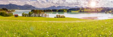 panoramic landscape with lake at springtime in front of mountain range