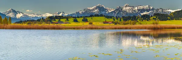 秋には山脈と湖が広がる田園風景へのパノラマビュー ロイヤリティフリーのストック画像