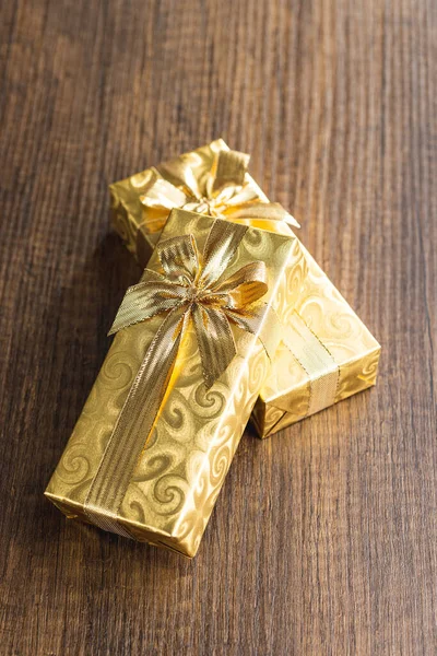 Δώρα Τυλιγμένα Χρυσό Χαρτί Χρυσό Φιόγκο Στο Ξύλινο Τραπέζι — Φωτογραφία Αρχείου