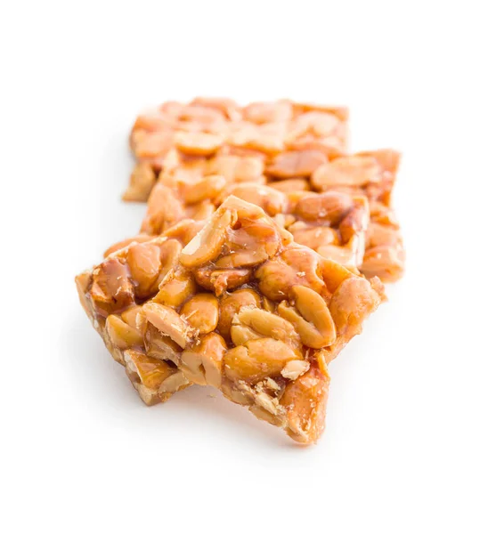 Sweet peanut brittle. Tasty peanuts in caramel isolated on the white background.