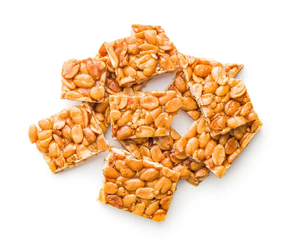 Sweet peanut brittle. Tasty peanuts in caramel isolated on the white background.