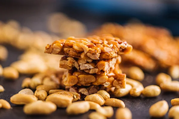 Sweet peanut brittle. Tasty peanuts in caramel on the kitchen table.