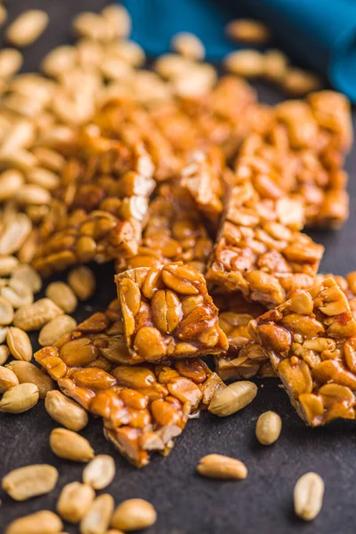Sweet peanut brittle. Tasty peanuts in caramel on the kitchen table.