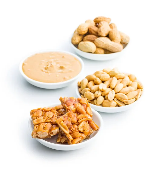 Sweet peanut brittle, peanuts and peanuts butter isolated on the white background.
