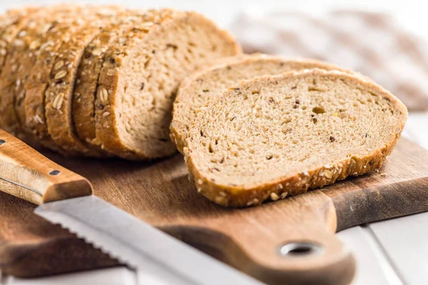 全粒穀物パンをスライス まな板の上の種とおいしい全粒粉のペストリー — ストック写真