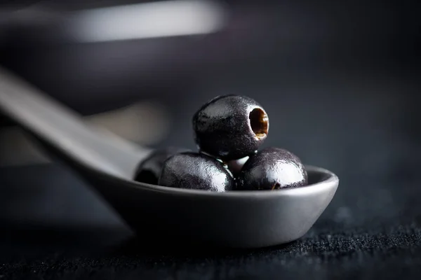 Pitted Black Olives Ceramic Spoon — Stock Photo, Image