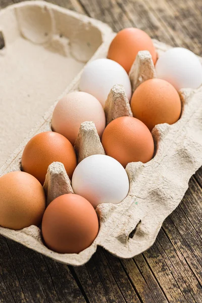木のテーブルの上の卵箱の中の鶏の卵 — ストック写真