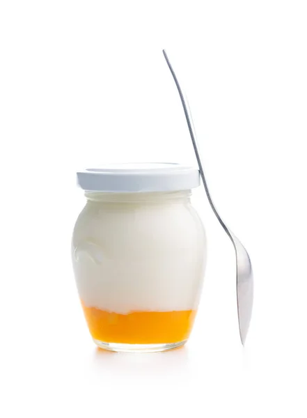 在白色背景下隔离的罐子和勺子中的水果酸奶 — 图库照片