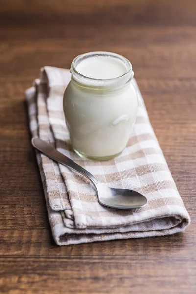 Yogurt Putih Dalam Guci Dan Sendok Pada Serbet Kotak Kotak — Stok Foto