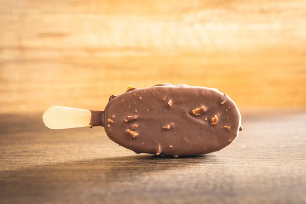 在木制桌子上涂满巧克力的冰淇淋 — 图库照片