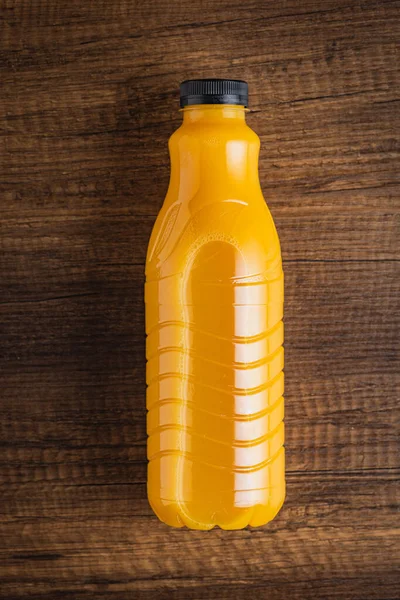 フルーツジュースのボトル 木製のテーブルの上にオレンジジュース トップ表示 — ストック写真
