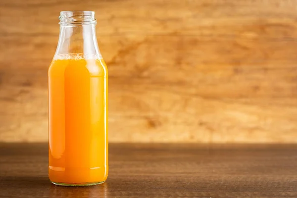 Una Botella Jugo Frutas Jugo Naranja Mesa Madera —  Fotos de Stock