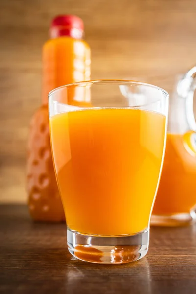 フルーツジュースのグラス 木製のテーブルの上のオレンジジュース — ストック写真